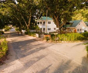 a street with a white house and trees at Villa Charette-Self Catering Villas in La Digue