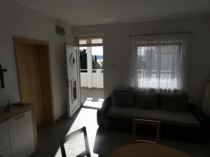 een woonkamer met een bank en een raam bij Tomo Apartment in Starigrad-Paklenica