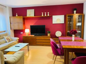 - un salon avec un canapé, une table et une télévision dans l'établissement Apartamentos Alcañiz, Gala, à Alcañiz