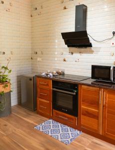 a kitchen with a stove and a microwave at Villa Charette-Self Catering Villas in La Digue