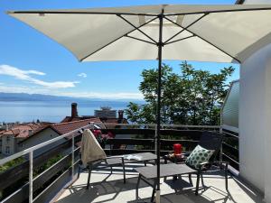 a balcony with two chairs and an umbrella at Gaja in Opatija