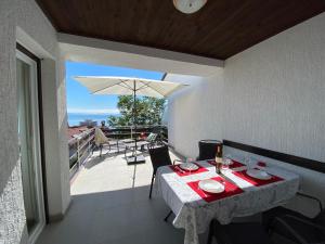 un tavolo e sedie su un balcone con vista di Gaja a Opatija