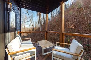a screened in porch with two chairs and a table at Night Owl cabin in Gatlinburg