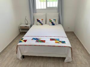 a bedroom with a large bed with white sheets and pillows at Kasentof in Cayenne