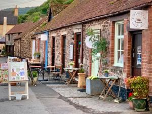 a brick building with tables and chairs in a street at Locanda on the Weir in Porlock +15 photos