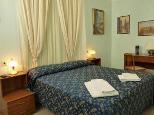 a bedroom with a bed with two towels on it at Hotel Ferraro in Rome