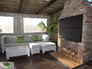 a living room with a couch and a brick fireplace at Princess Holiday Home in Cape Town