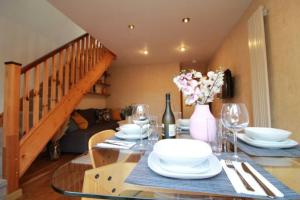 a dining room with a table with plates and wine glasses at Cheerful Two-Bedroom Residential Home in Oxford