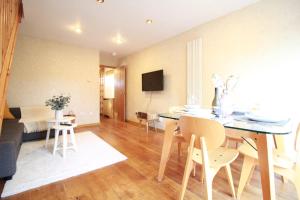 a living room with a table and chairs and a couch at Cheerful Two-Bedroom Residential Home in Oxford