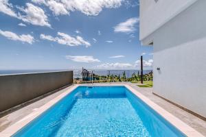 una piscina con vistas al océano desde una casa en Casa das Voltinhas en Ponta do Sol