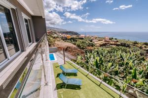 a balcony with two chairs and a view of the ocean at Casa das Voltinhas in Ponta do Sol