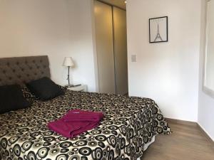 een slaapkamer met een bed met een paarse handdoek erop bij Departamento Boutique II en Nueva Cordoba in Cordoba