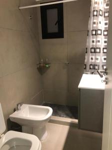 a bathroom with a white toilet and a sink at Departamento Boutique II en Nueva Cordoba in Córdoba
