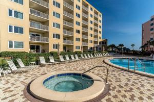 ein Hotel mit einem Pool und Stühlen sowie einem Gebäude in der Unterkunft Islander 203 - Dances with Dolphins in Destin