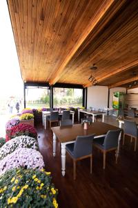a dining room with tables and chairs and flowers at Villa Nora Butik Otel ve Bungalov in Bursa