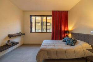 a bedroom with a large bed with a red curtain at Mexico Historic Center Modern Apartment in Mexico City