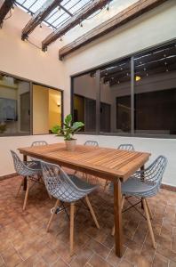 a wooden table and chairs with a potted plant at Mexico Historic Center Modern Apartment in Mexico City