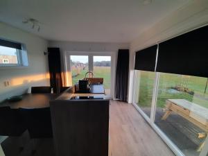 a living room with a large window and a table at De Weitens Valkenswaard in Valkenswaard