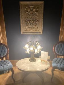 einen Tisch mit einer Lampe in einem Zimmer mit 2 Stühlen in der Unterkunft Grand Central Hotel in Eureka Springs