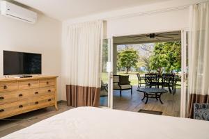 a bedroom with a bed and a television and a table at Pavones Point in Pavones