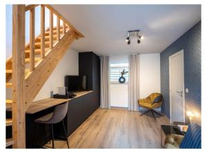 een kamer met een trap en een bureau met een televisie bij B&B De Floreffe in Overpelt