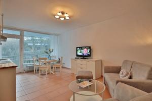 een woonkamer met een bank, een tv en een tafel bij Domizil Strandallee 30 Domizil Strandallee 30 Appartement 28 in Timmendorfer Strand
