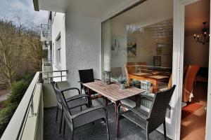 een patio met een houten tafel en stoelen op een balkon bij Domizil Strandallee 30 Domizil Strandallee 30 Appartement 28 in Timmendorfer Strand