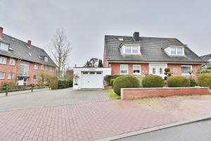 a house with a driveway and a white garage at Hainholz Hainholz Bungalow Hemmelsdorf in Hemmelsdorf