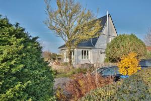 a white house with a car parked in front of it at Haus zur Niendorfer Sonne Haus Schwalbennest in Niendorf