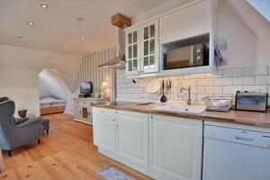 a kitchen with white cabinets and a sink at Haus zur Niendorfer Sonne Haus Schwalbennest in Niendorf