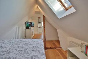 a attic bedroom with a bed and a television at Haus zur Niendorfer Sonne Haus Schwalbennest in Niendorf