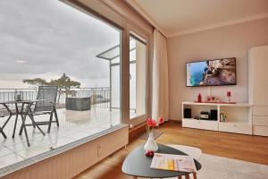ein Wohnzimmer mit einem großen Fenster und einem Balkon in der Unterkunft Haus Seebrücke Haus Seebrücke Appartement 02 in Niendorf