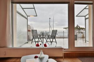a room with a window with a table and chairs on a balcony at Haus Seebrücke Haus Seebrücke Appartement 02 in Niendorf