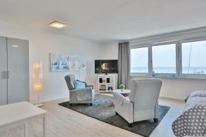a living room with a bed and two chairs at Haus Seebrücke Haus Seebrücke Appartement 10 in Niendorf
