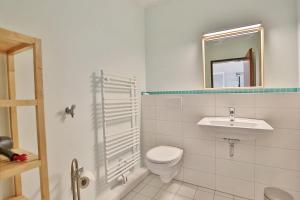 a bathroom with a toilet and a sink and a mirror at Haus Seebrücke Haus Seebrücke Appartement 10 in Niendorf +5 photos