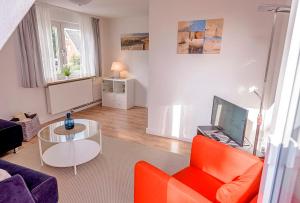 sala de estar con sofá, mesa y TV en Haus Lubecca Ferienhaus Lubecca Appartement 01, en Timmendorfer Strand