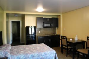 a hotel room with a bed and a kitchen with a refrigerator at Crown Inn Motel Yorktown in Yorktown