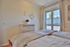 ein Schlafzimmer mit einem Bett und einem großen Fenster in der Unterkunft Gorch-Fock-Straße 16 Gorch-Fock-Str 16a Appartement 10 in Timmendorfer Strand