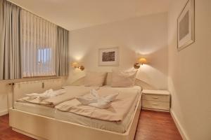 un letto bianco in una stanza con finestra di Gorch-Fock-Park Haus 02 Gorch Fock Park 2 Appartement 02 a Timmendorfer Strand