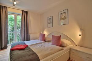 una camera da letto con un grande letto con cuscini rosa di Gorch-Fock-Straße 16 Gorch-Fock-Str 16 Appartement 2 a Timmendorfer Strand