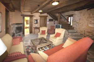 a living room with couches and a fireplace at Casa Rural Las Águedas in Murias de Rechivaldo