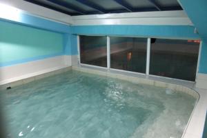 una grande piscina d'acqua in una stanza con finestra di Villa Sparadise a Ohrid