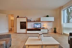 - un salon avec un canapé et une télévision dans l'établissement Villa Mér Baltique Villa Mér Baltique Appartement 20, à Timmendorfer Strand
