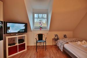a bedroom with a bed and a tv and a window at Ferienhaus Wohldkamp Ferienhaus Wohldkamp in Timmendorfer Strand