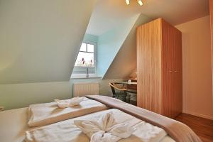 a bedroom with a bed with white sheets and a window at Ferienhaus Wohldkamp Ferienhaus Wohldkamp in Timmendorfer Strand