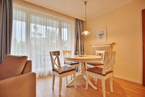 uma sala de jantar com uma mesa e cadeiras e uma janela em Ferienanlage Bergstraße 62 Ferienhaus Bergstraße 62 Appartement 11 em Timmendorfer Strand