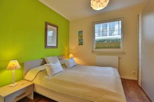 - une chambre verte avec un lit et une fenêtre dans l'établissement Residenz Herrenbruchstr Residenz Herrenbruchstraße 5 Appartement 1, à Timmendorfer Strand