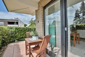 eine Terrasse mit einem Tisch und Stühlen auf einer Veranda in der Unterkunft Haus Sommerbrise Haus Sommerbrise Appartement 4 in Timmendorfer Strand