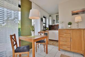eine Küche mit einem Esstisch aus Holz und Stühlen in der Unterkunft Haus Sommerbrise Haus Sommerbrise Appartement 4 in Timmendorfer Strand