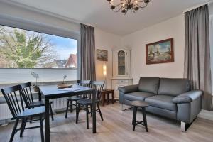 Una sala de estar con un sofá, una mesa y sillas. en Carpe Diem Carpe Diem Appartement 093, en Niendorf